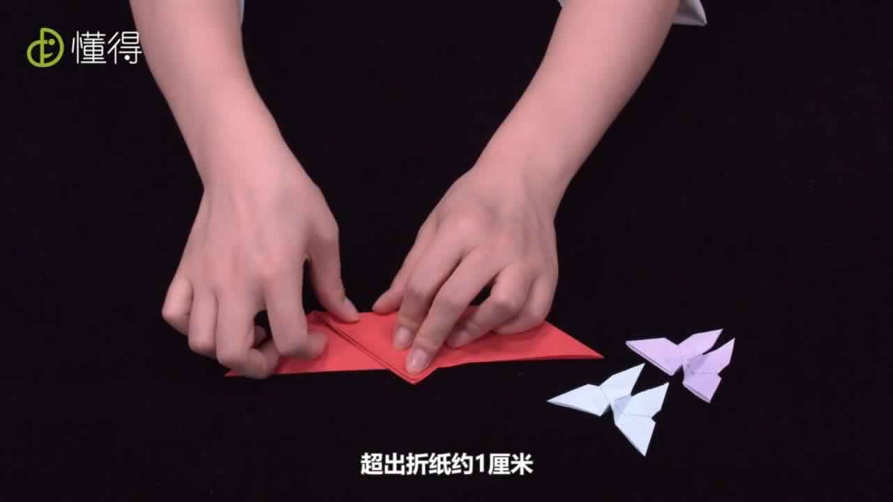 将下面的角向上折起，超出折纸约1厘米