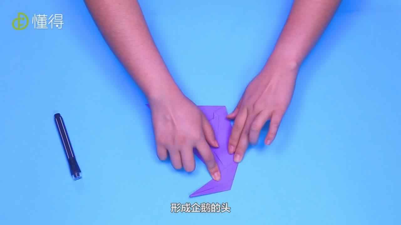 沿折痕向右套着翻折过去，形成企鹅的头